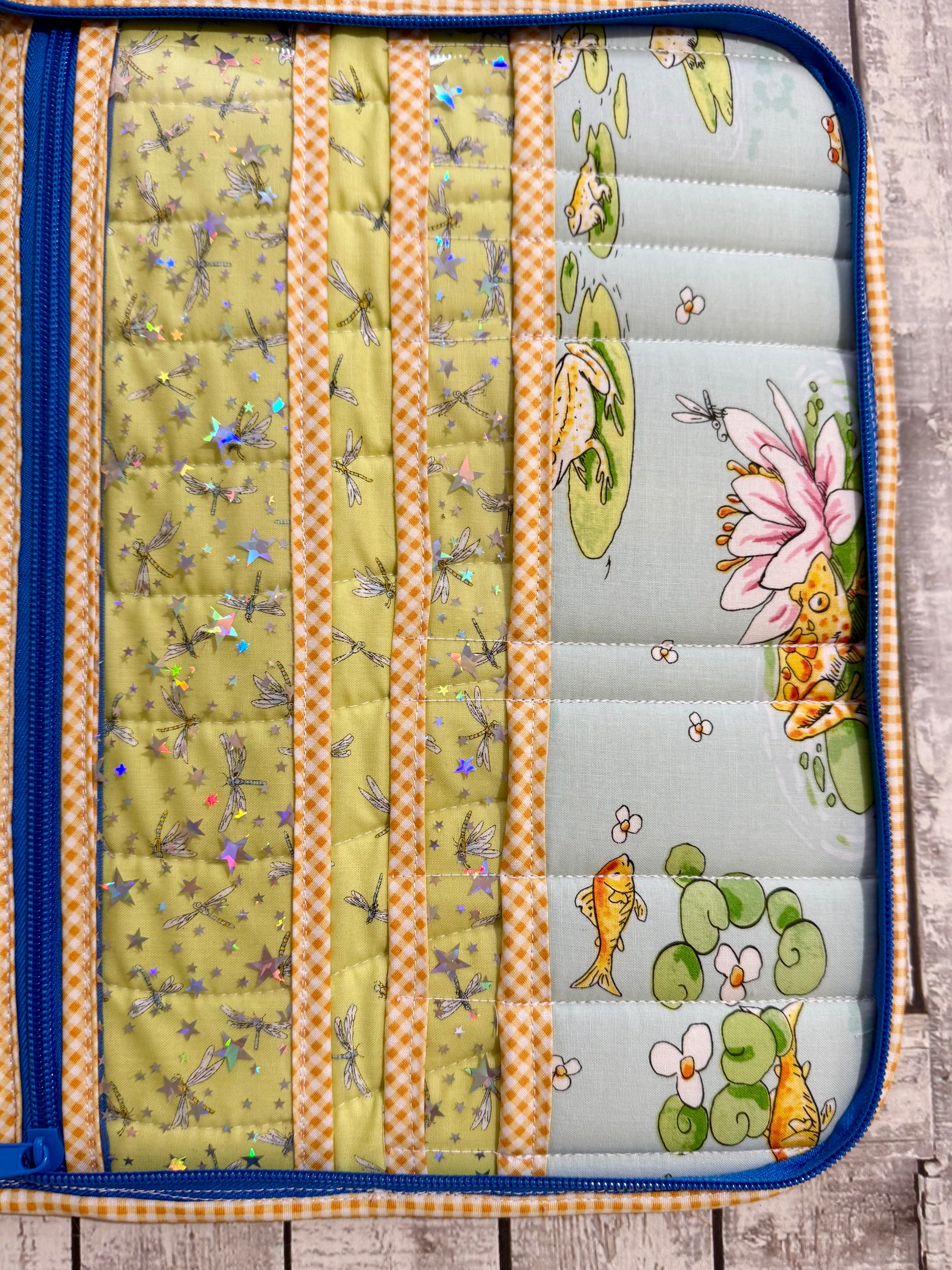 Close up of vinyl and quilted pockets with dragonfly fabric and frog print inside tool organizer