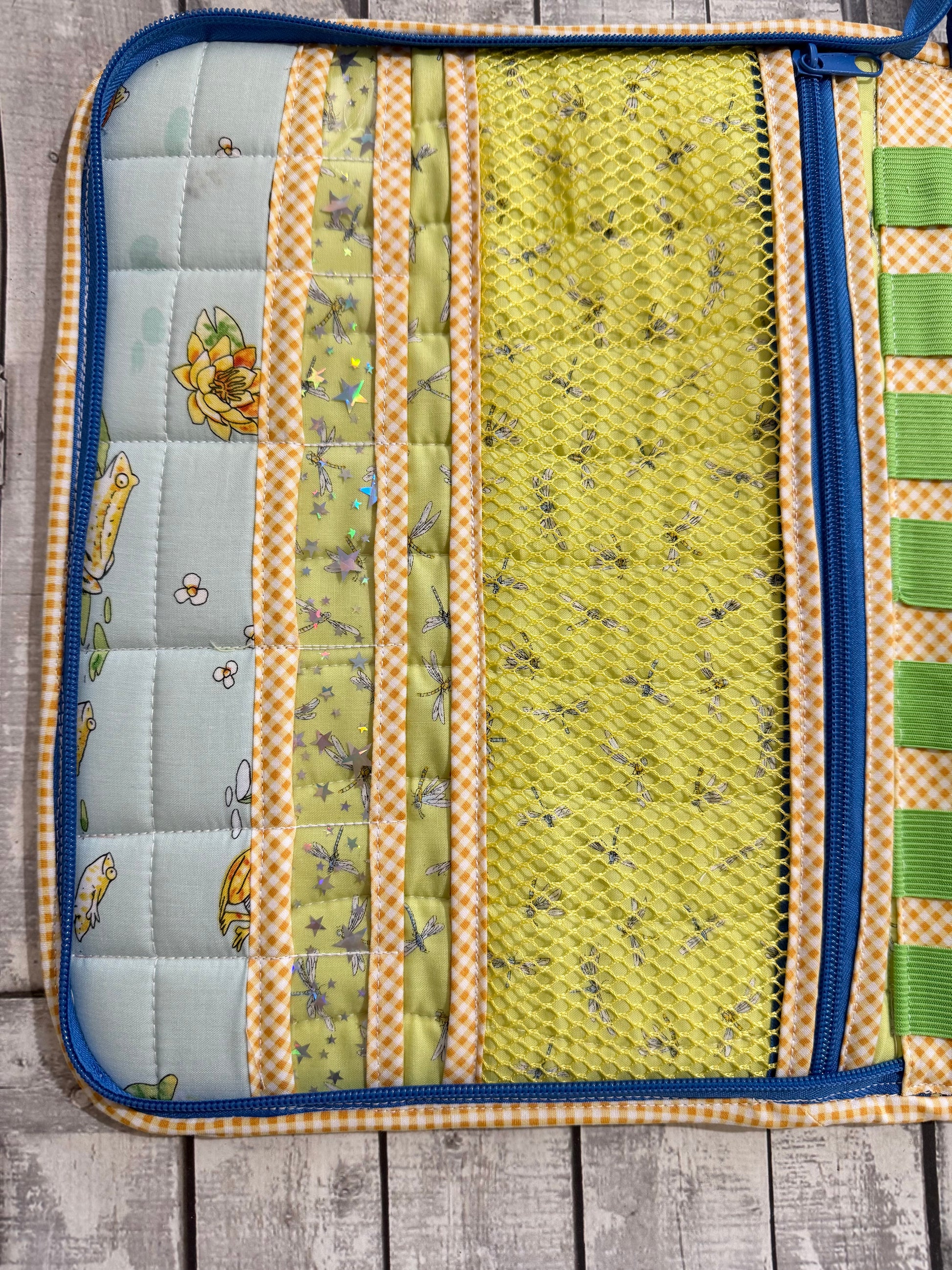 Quilted sewing organizer with yellow mesh pocket and dragonfly fabric, elastic loops not visible