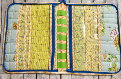 Inside of sewing tool organizer with mesh pockets, vinyl pockets, and elastic loops in green and gingham prints
