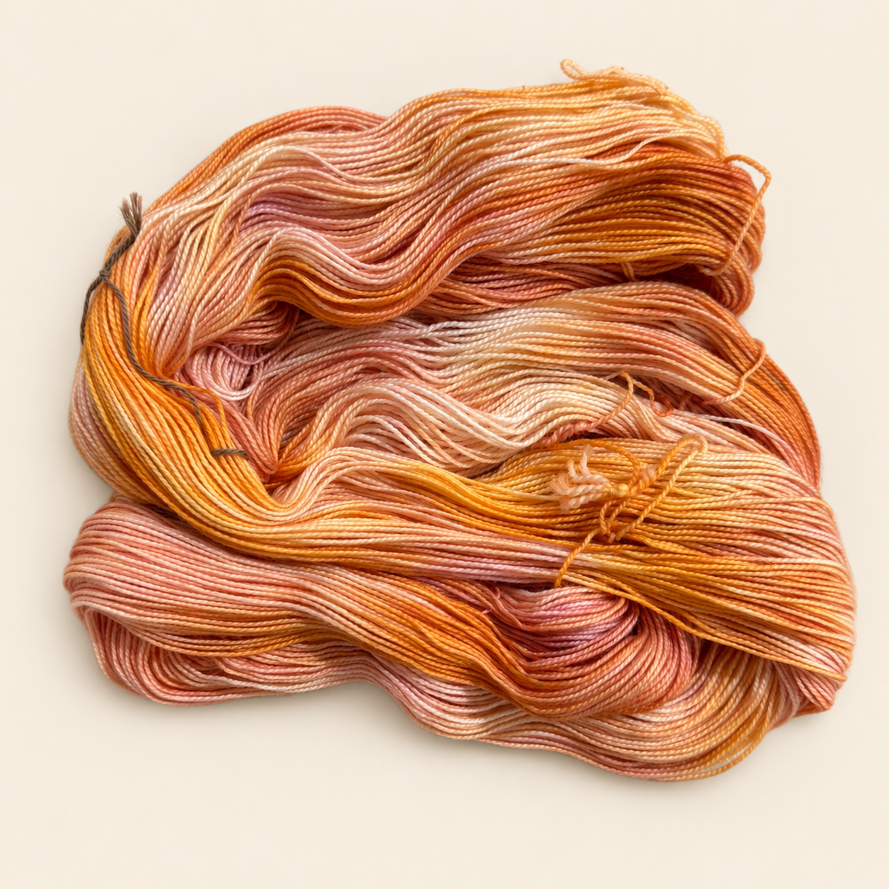 a product photo of one skein of an orange and pink hand dyed variegated yarn from toad hollow.  The yarn is untwisted to see all the colors and variegation